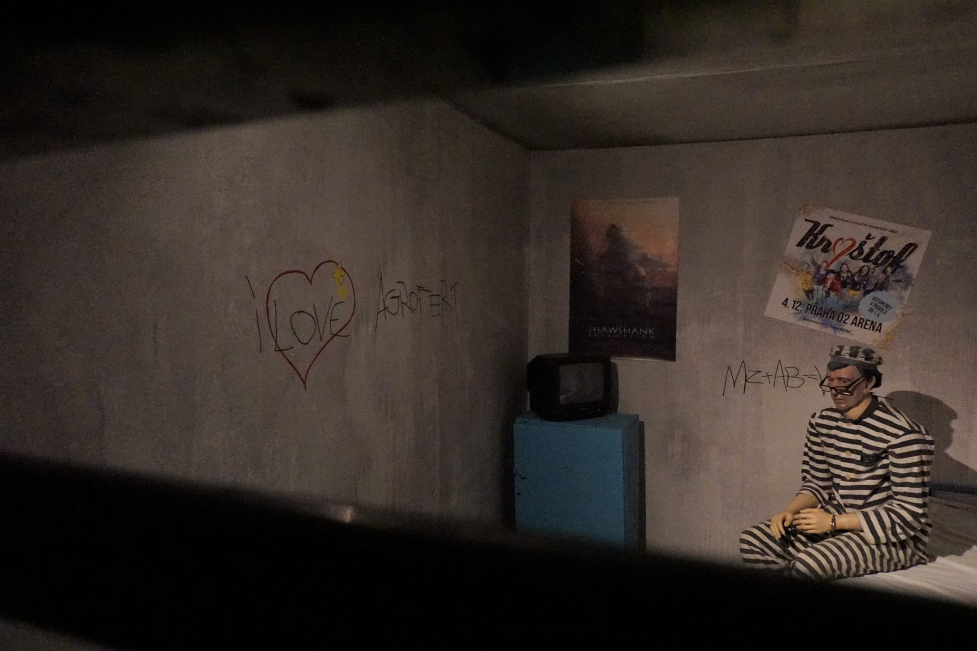 Ve vězeňské cele Andreje Babiše lze spatřit vyrytý vzkaz ve zdi „I love Agrofert“, opodál je pak plakát ikonického snímku Vykoupení z věznice Shawshank, ale také plakát skupiny Kryštof.