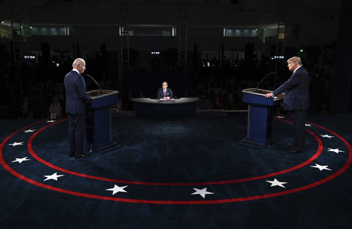 Úřadující americký prezident Donald Trump a jeho vyzyvatel Joe Biden (vpravo) během první předvolební debaty, kterou moderoval Chris Wallace (uprostřed).