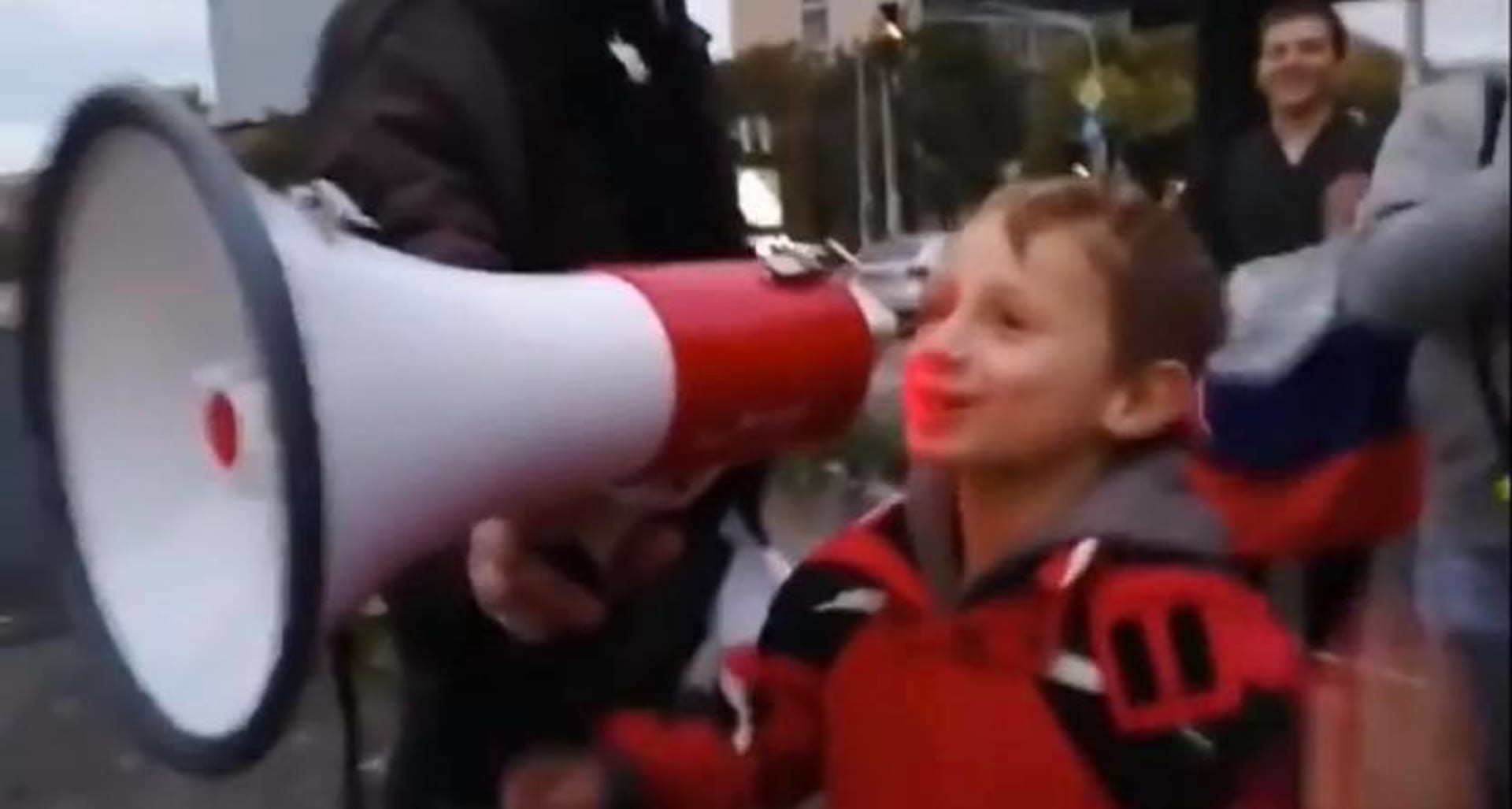 Chlapec je jedním ze tří dětí, které při sobotním protestu skandovaly nadávky do megafonu.