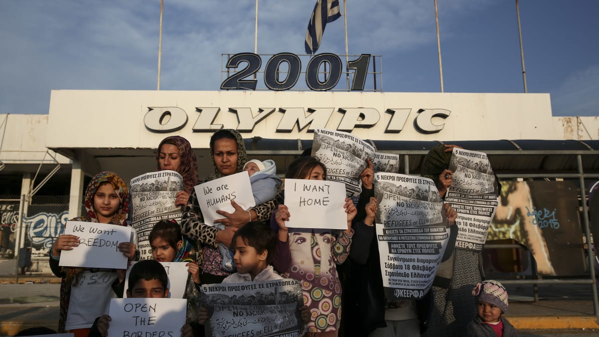 Jsme lidé. Chceme svobodu. Otevřete hranice. Tyto nápisy třímají v rukou matky s dětmi před bývalým olympijským komplexem Helleniko v řeckých Aténách.