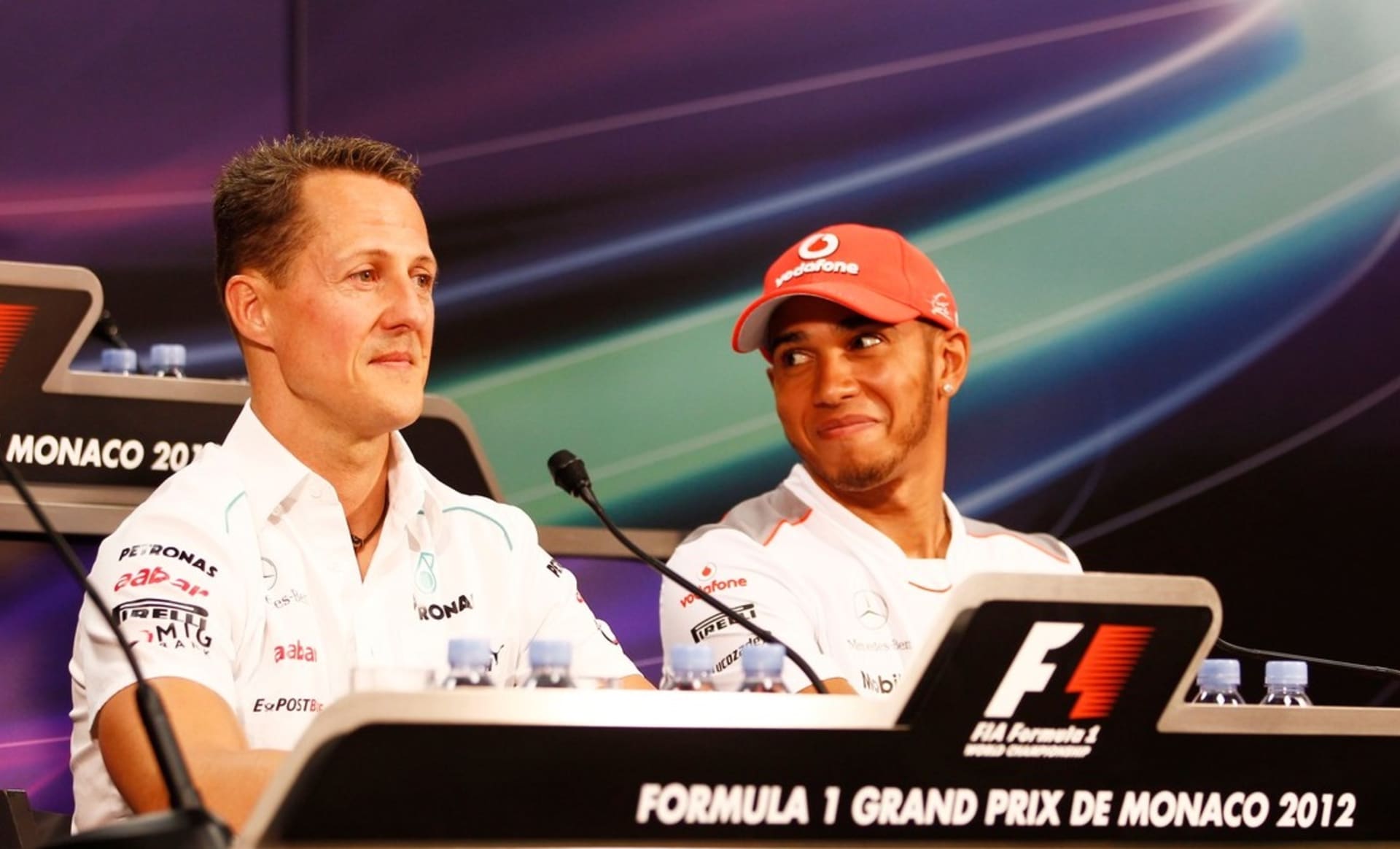 Michael Schumacher (vlevo) a Lewis Hamilton na tiskové konferenci před Grand Prix Monaka v roce 2012