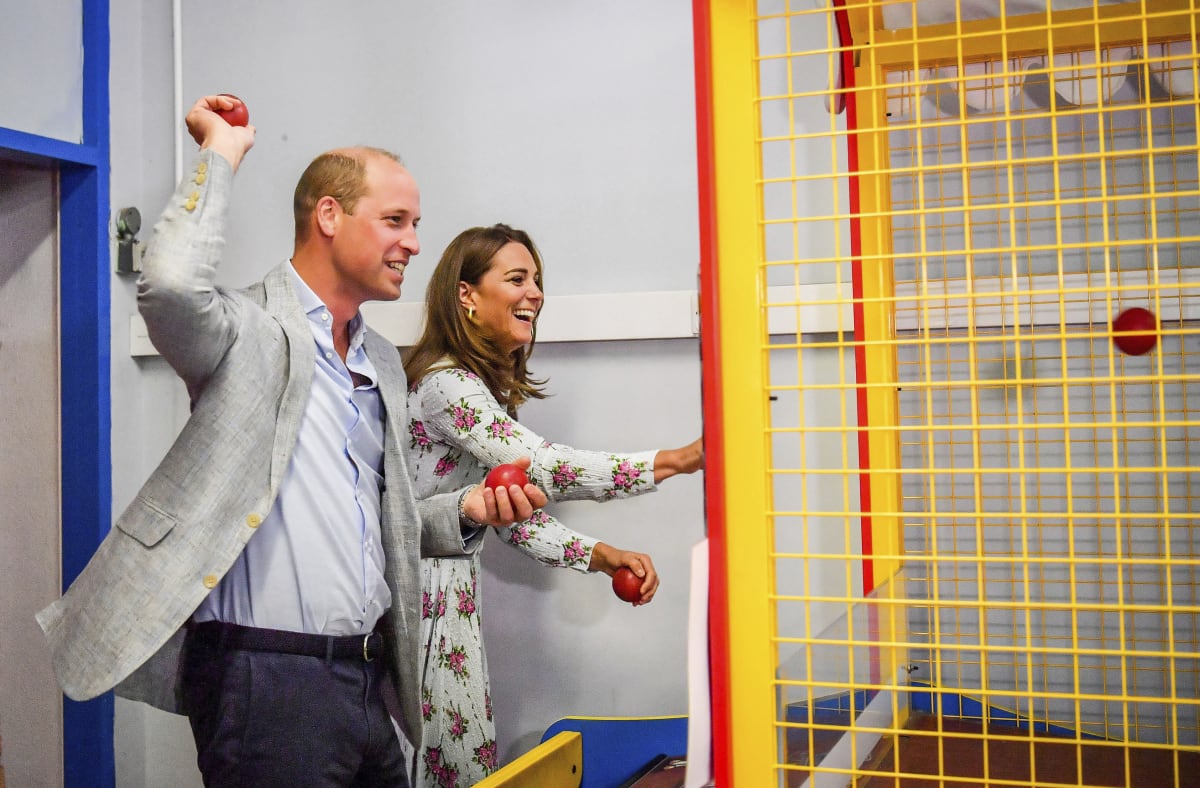 Princ William a vévodkyně Kate házejí míčky v dětském koutku. 