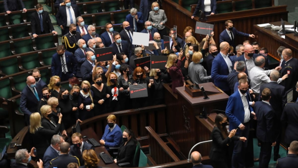 Opoziční poslankyně v Sejmu obklopily koaliční politiky s transparenty. 