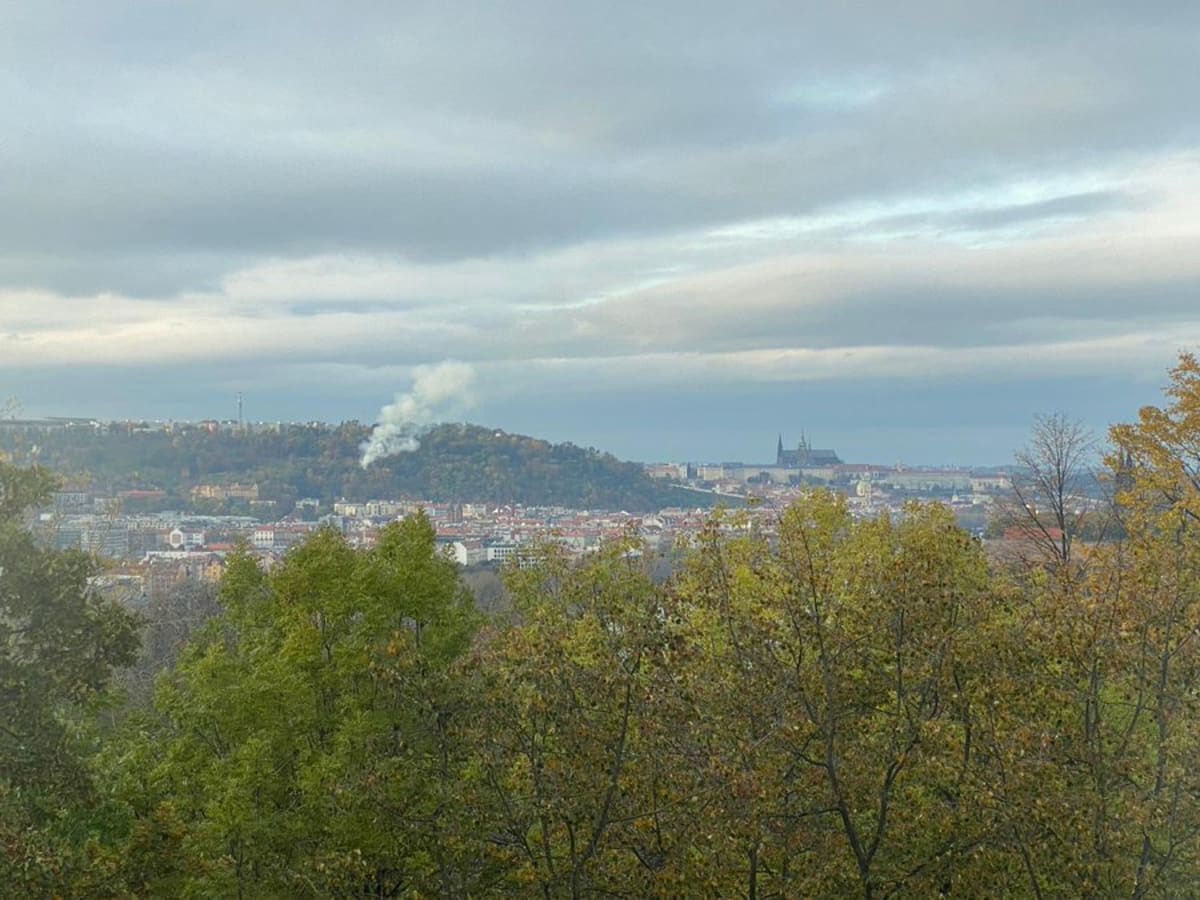 Kouř vycházející z pražské zahrady Kinských, kde hoří dřevěný kostel sv. Michala, je vidět už z dálky. (foto: Hasiči Praha)