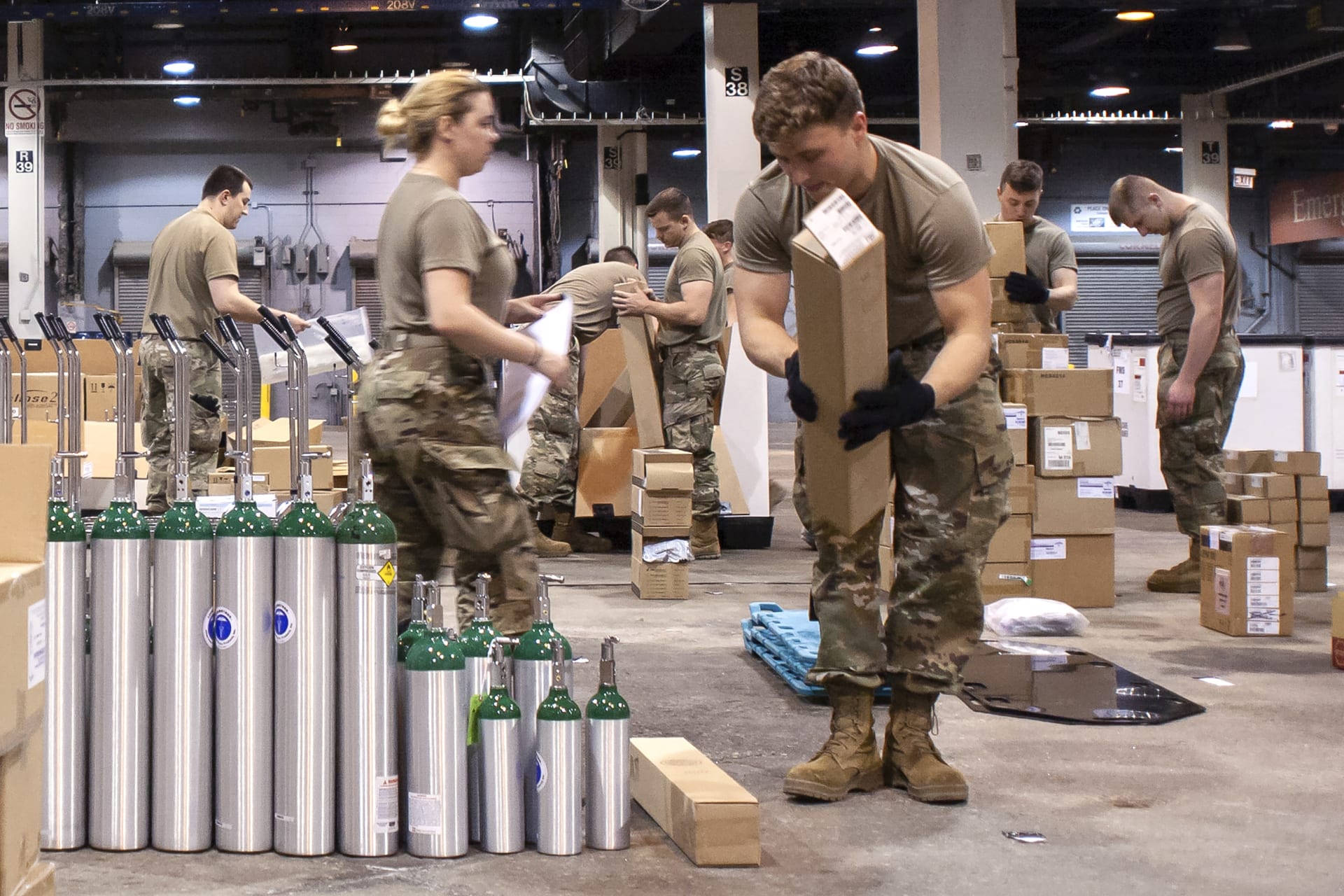Američtí vojáci připravují kyslíkové láhve a další materiál během pandemie koronaviru. 
