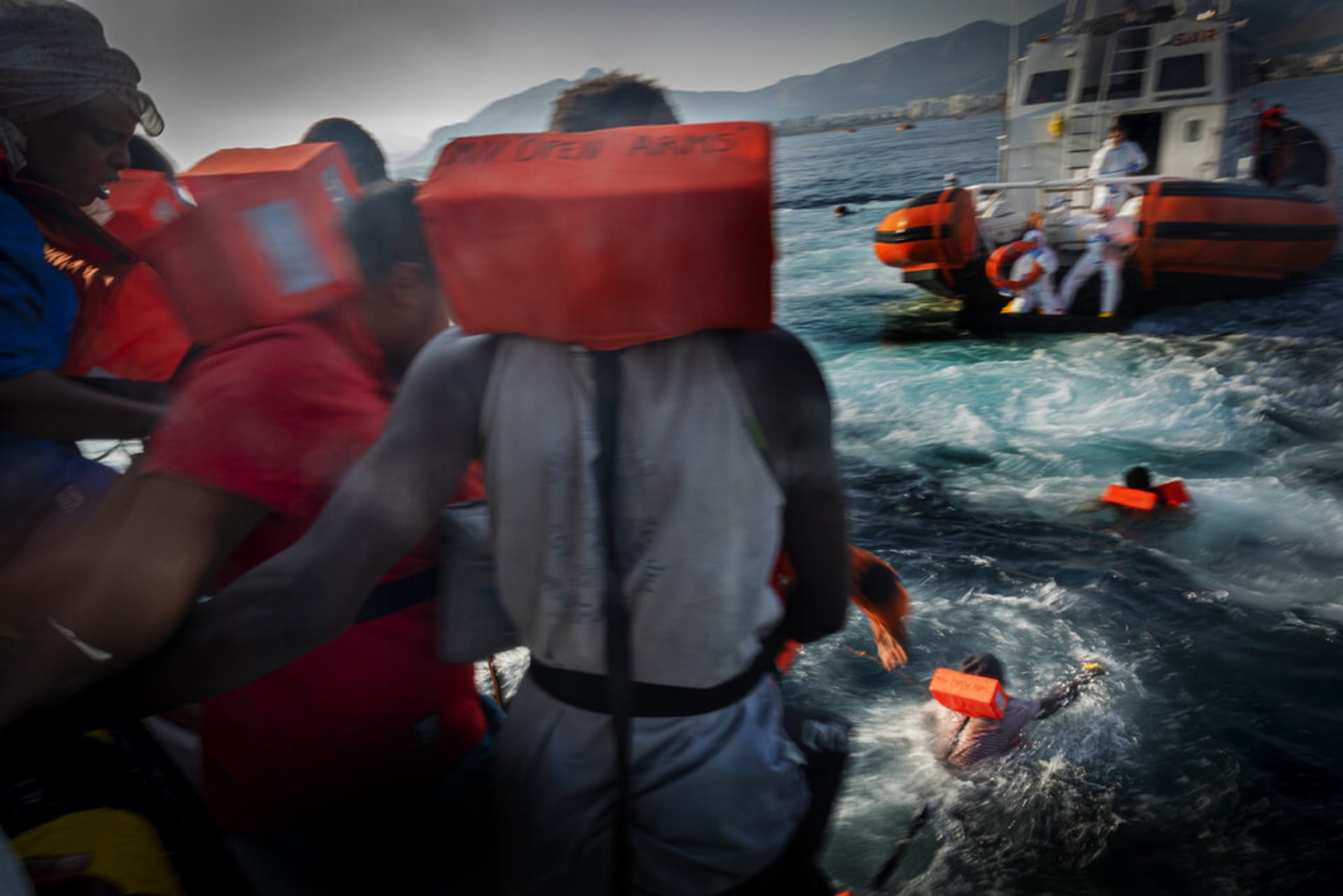 Migranti se pokoušejí zachránit skokem k lodi pobřežní stráže. (Ilustrační snímek)