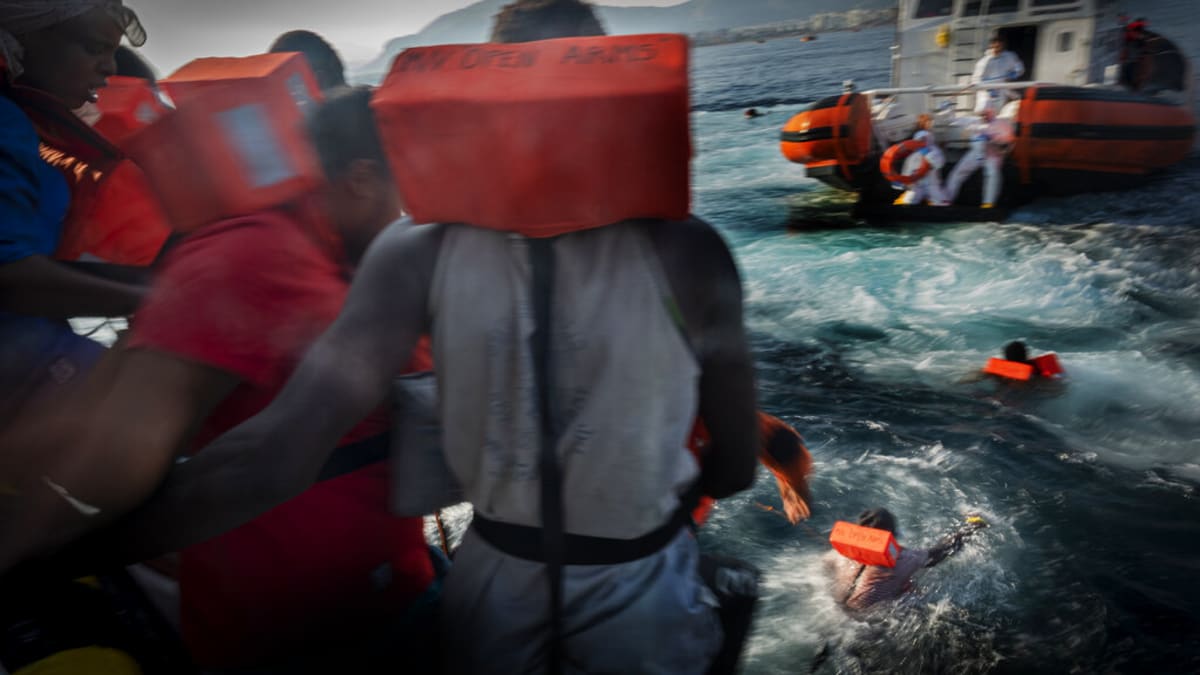 Migranti se pokoušejí zachránit skokem k lodi pobřežní stráže. (Ilustrační snímek)