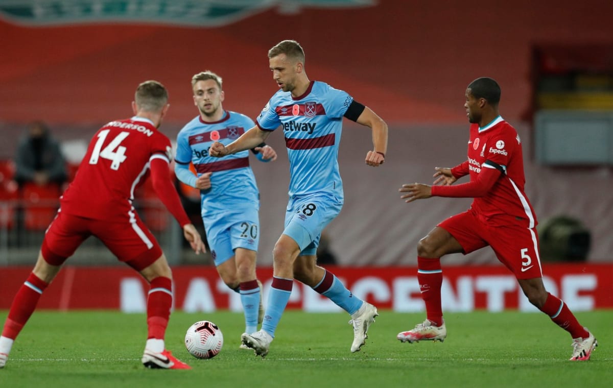 Český záložník Tomáš Souček (uprostřed) se snaží projít obranou FC Liverpool.