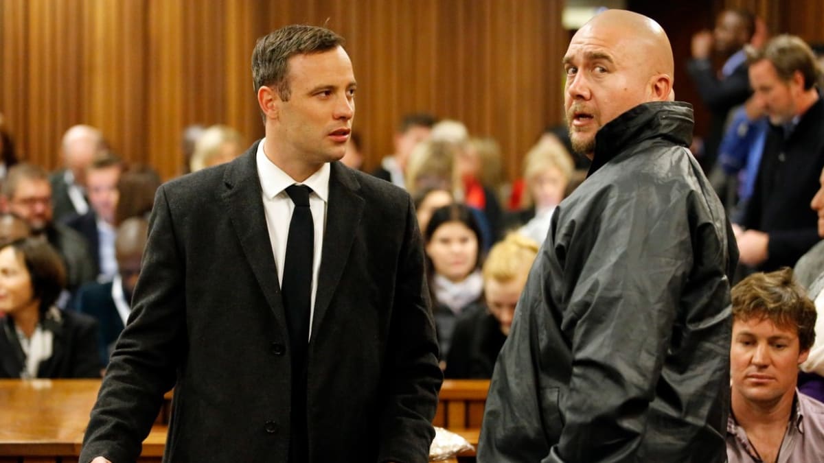 Oscar Pistorius (vlevo) u soudu, kde se hned několikrát objevil kvůli vraždě své přítelkyně, ke které došlo v roce 2013.