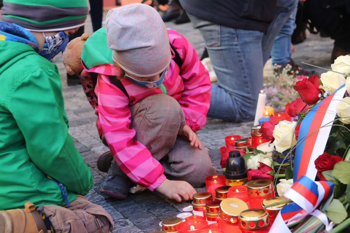 Děti zapalují svíčky na Národní třídě.