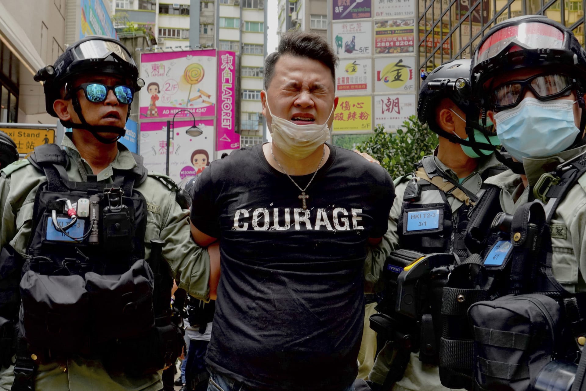Hongkongští policisté odvádějí demonstranta.