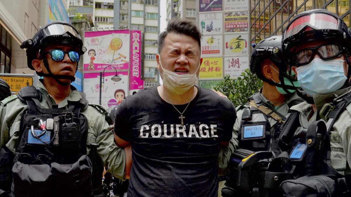Hongkongští policisté odvádějí demonstranta.