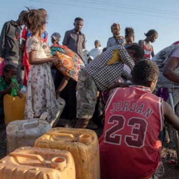 Etiopský utečenec si poblíž hranice mezi Súdánem a Etiopií napouští galon vodou. 