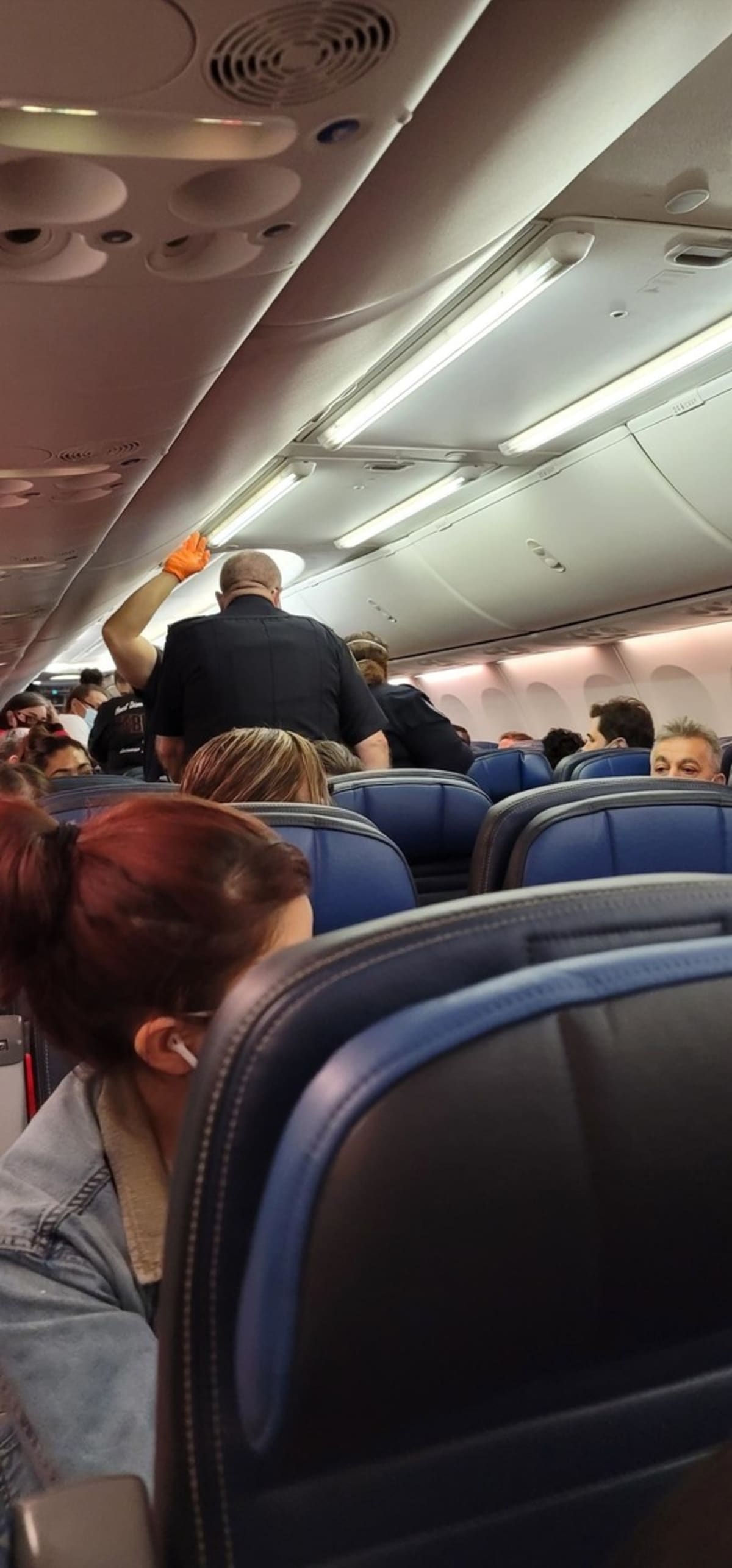Fotografie dokazující chaos, který vznikl na palubě letadla poté, co muž s covidem zkolaboval a následně zemřel