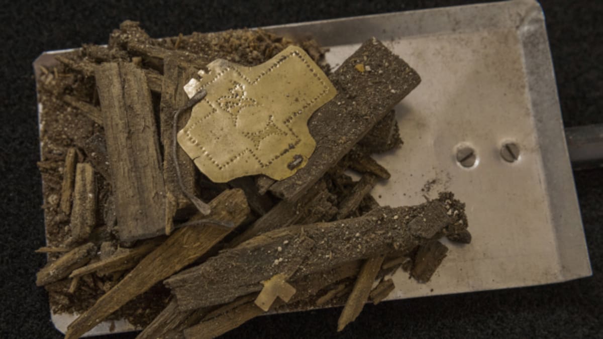 Trosky dřevěného relikviáře se zlatou destičkou zdobenou tepáním (kříž a písmena "IR"). Archeologové objevili v milevském klášteře na Písecku schránku s odseknutou částí hřebu z Pravého kříže. Jedná se o jednu z nejvzácnějších křesťanských relikvií (zdroj: PR/Martin Frouz)