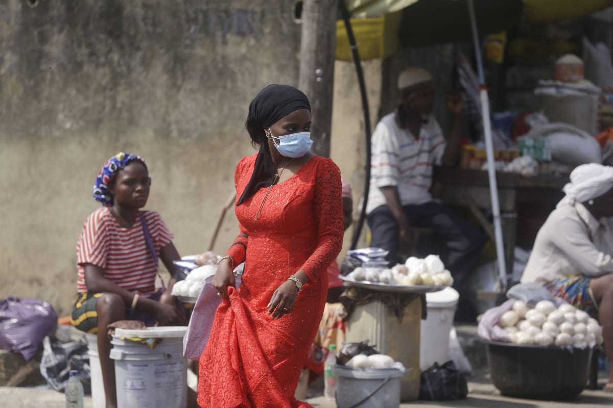 Žena s rouškou na trhu ve městě Lagos