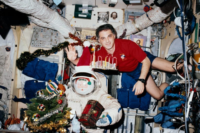 Mir Expedition 24 a astronaut NASA David A. Wolf se svou menorou a dreidlem na oslavu Chanuky v roce 1997. 
