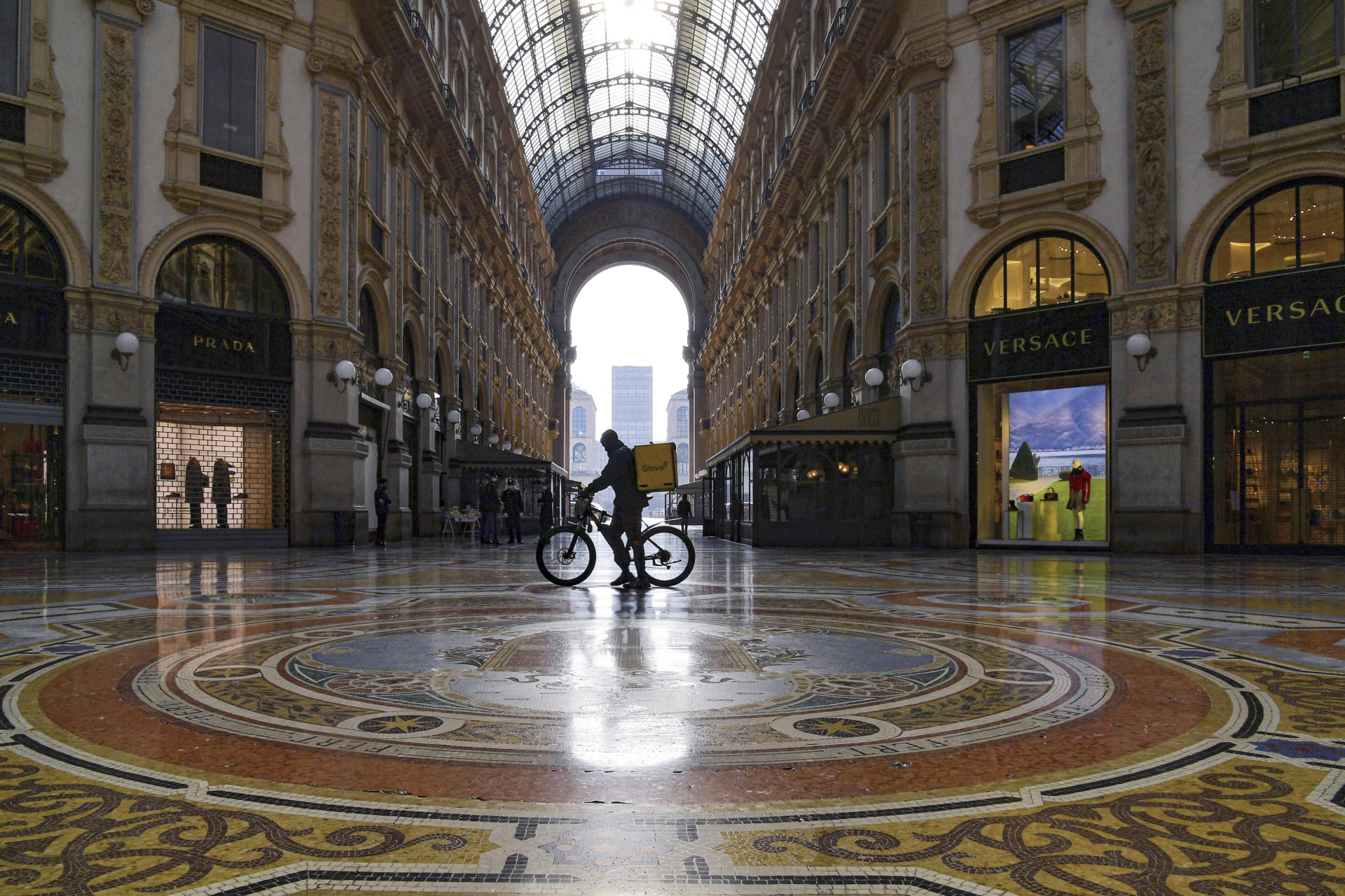 Výjimečný stav v Miláně. Opuštěná nákupní galerie Viktora Emanuela, kterou prochází poslíček s jídlem.