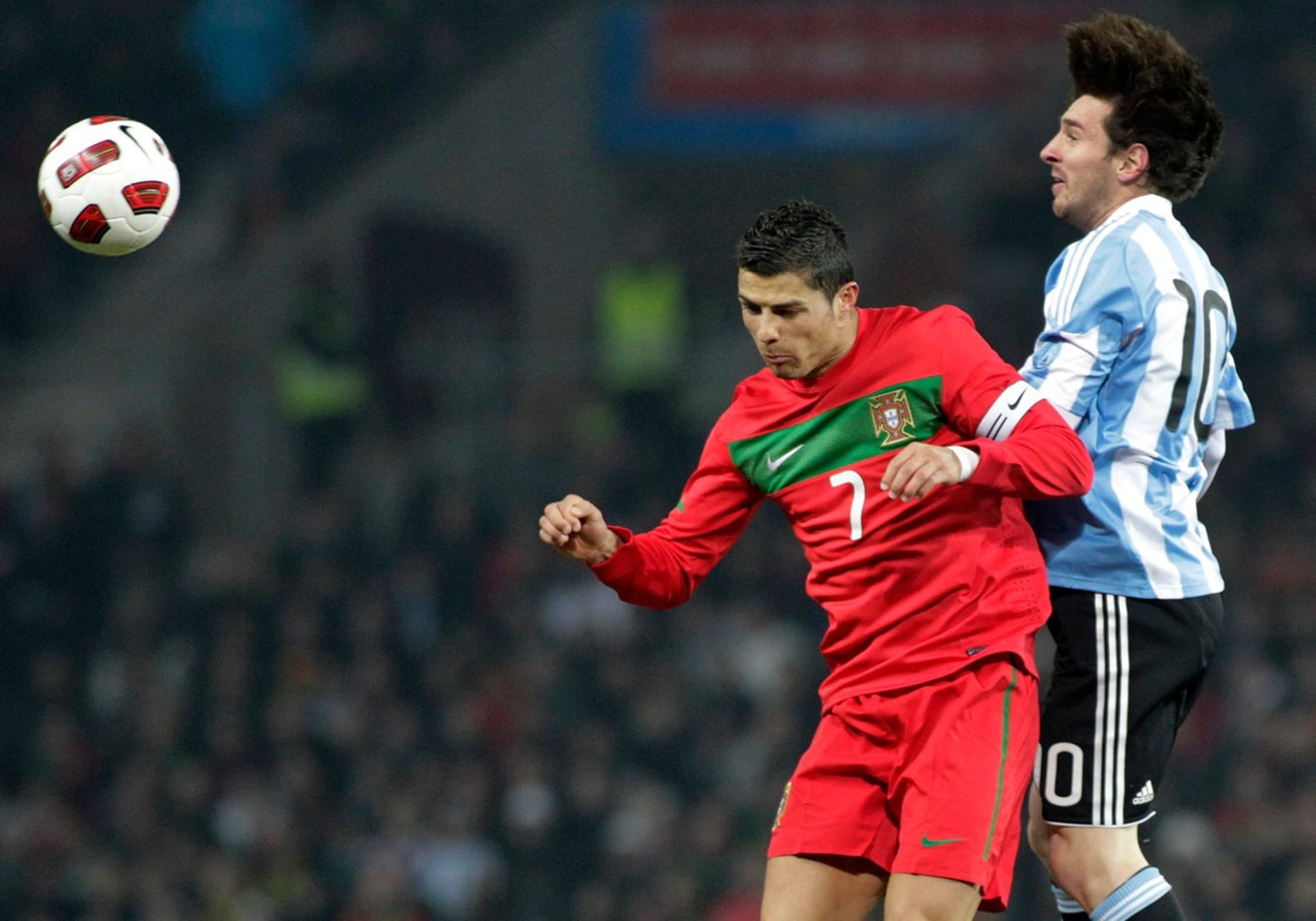 Lionel Messi (vpravo) v hlavičkovém souboji s Cristianem Ronaldem při jejich prvním vzájemném utkání v reprezentacích Argentiny a Portugalska.