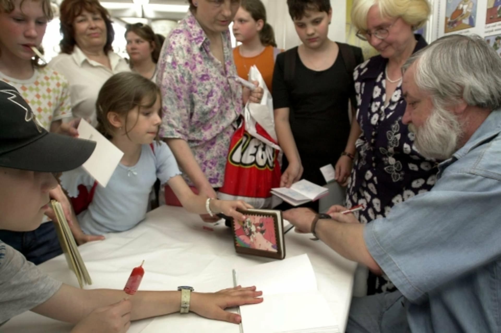 Spisovatel Vojtěch Steklač podepisuje dětem knihy na své autogramiádě. 