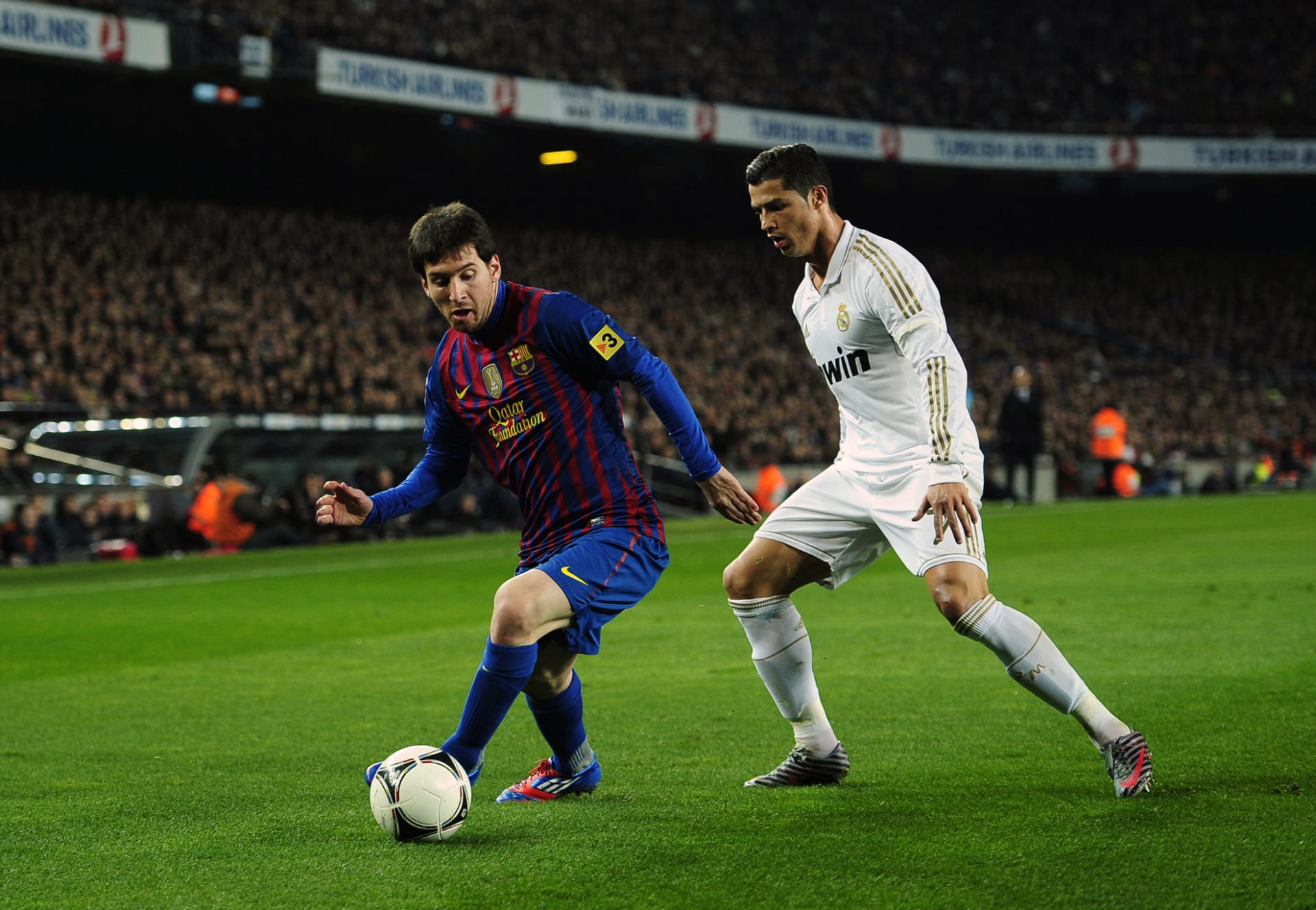 Lionel Messi obchází Cristiana Ronalda.