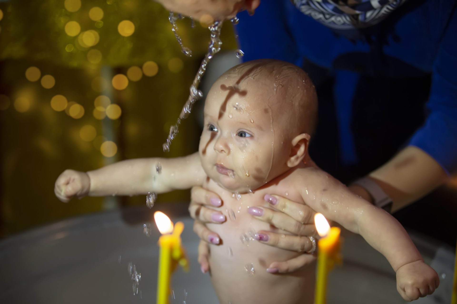 Při křtu v pravoslavné církvi je dítě třikrát ponořeno do kádě se svěcenou vodou.