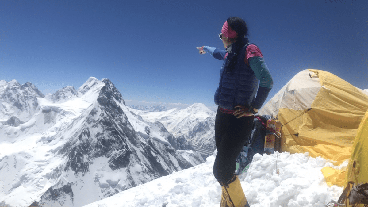 Klára Kolouchová hledí a ukazuje na K2. 