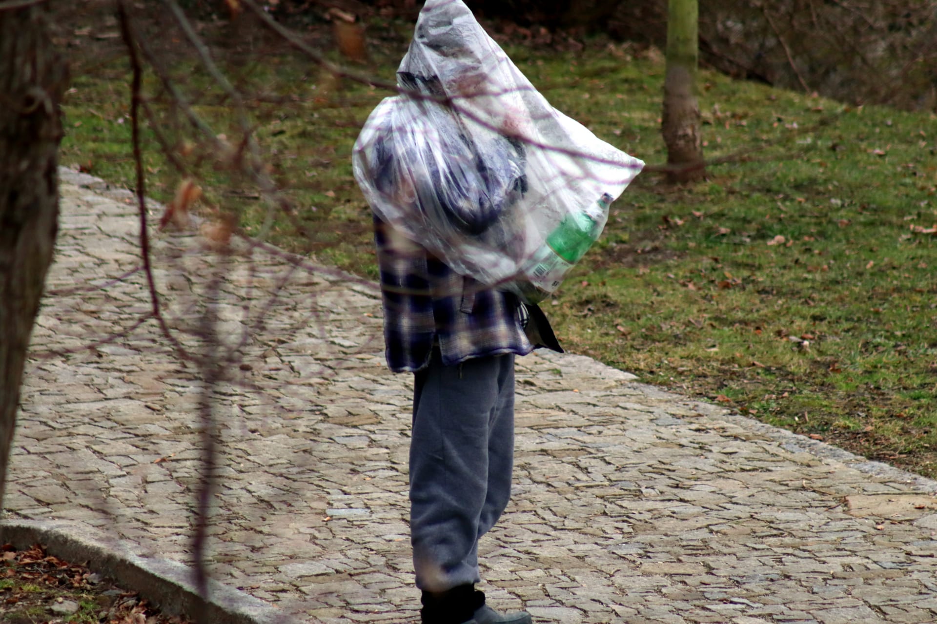 Bezdomovec se v Českých Budějovicích chrání proti nákaze tím, že se po parku pohybuje v igelitovém pytli.