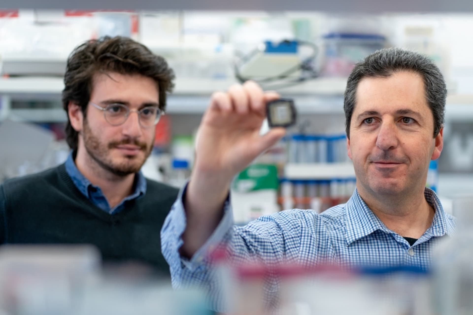 Profesor Nahmias (vpravo) a člen výzkumného týmu Aaron Cohen. Nahmias v ruce drží čip simulující reakce lidského těla.