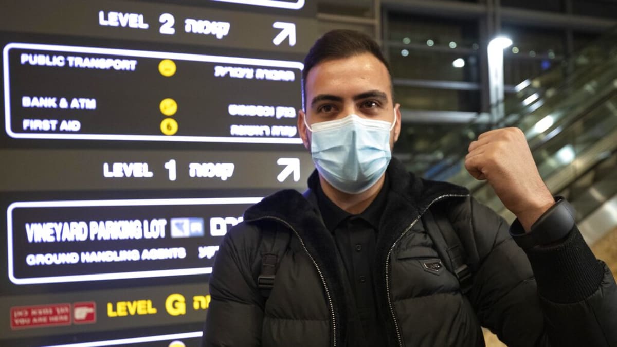 Izraelský občan po návratu do země ukazuje sledovací náramek na své ruce.