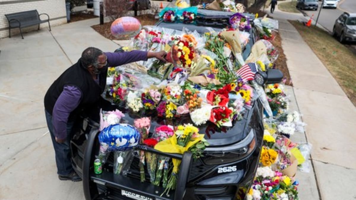 Američané zavalili služební auto zesnulého policisty Erica Talleyho květinami a vzkazy.