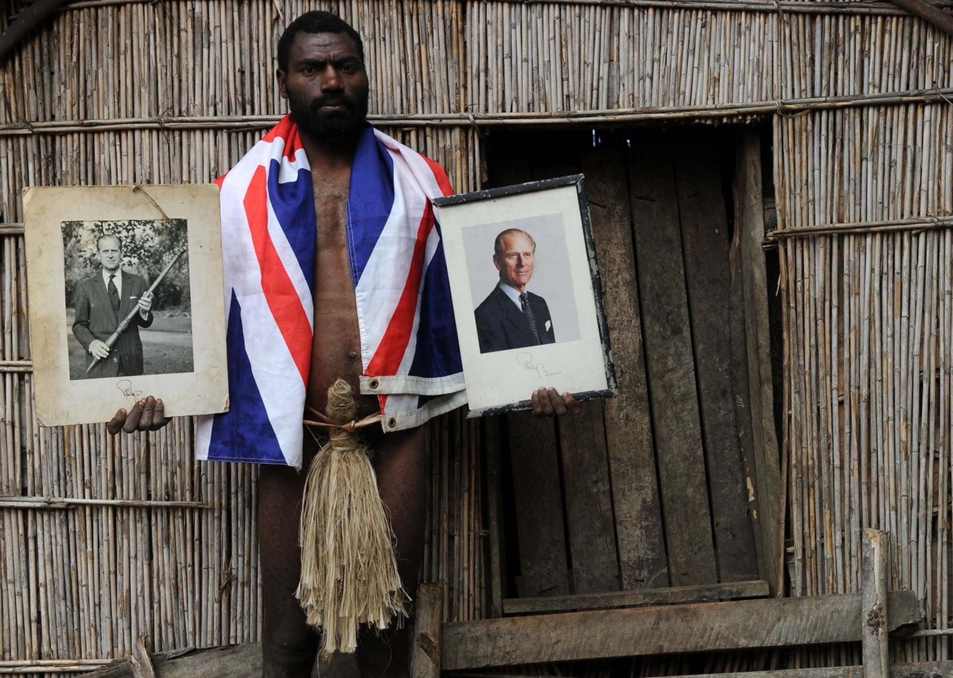 Jeden z vesničanů pózující s fotografií svého velkého vzoru prince Philipa. 