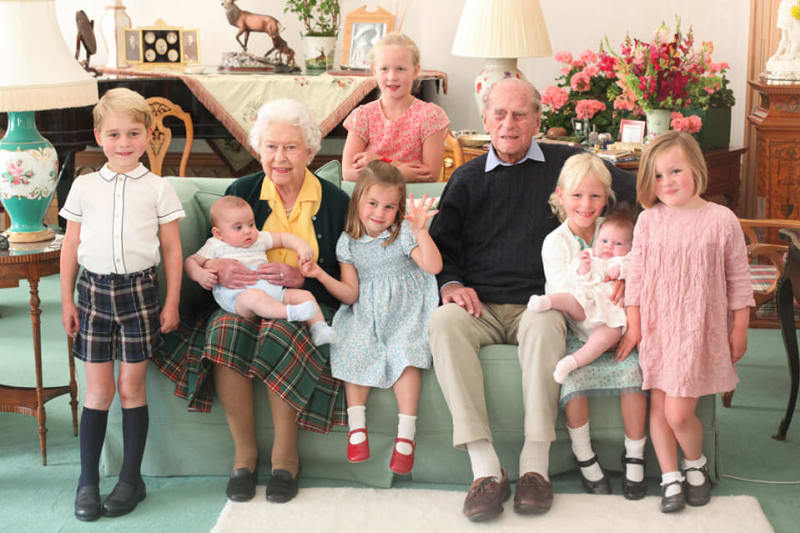 Královská rodina na společné fotografii se sedmi pravnoučaty. Vlevo stojí pravnuk princ George, vedle královny sedí princezna Charlotte. Královna drží prince Louise.
