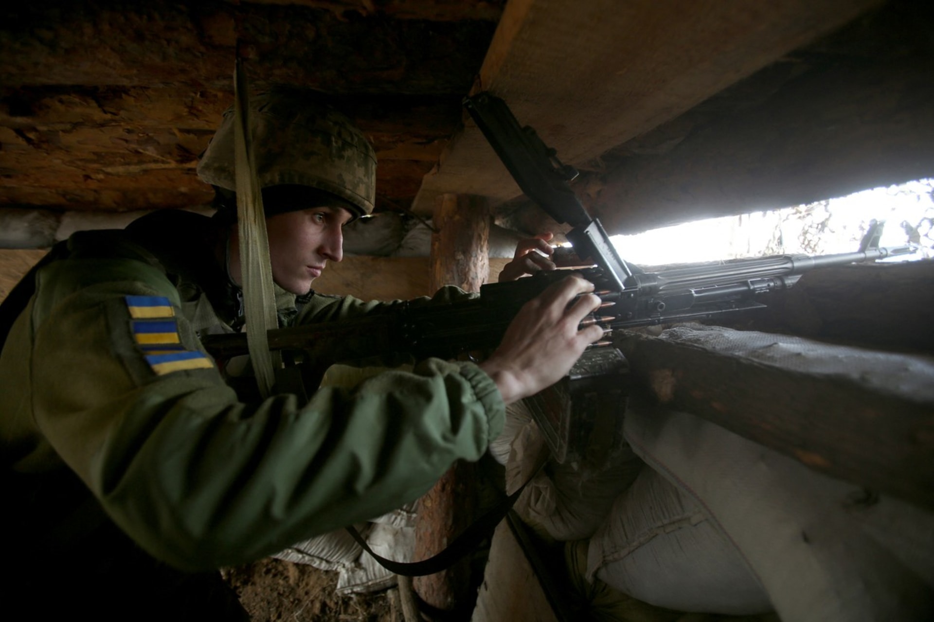 Ukrajinský voják vyhlíží na frontě nepřítele.