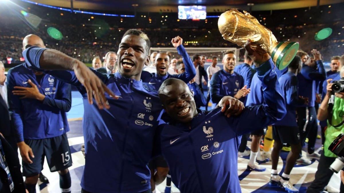 Kanté držící trofej pro mistry světa. Objímá ho spoluhráč z francouzské reprezentace Paul Pogba.