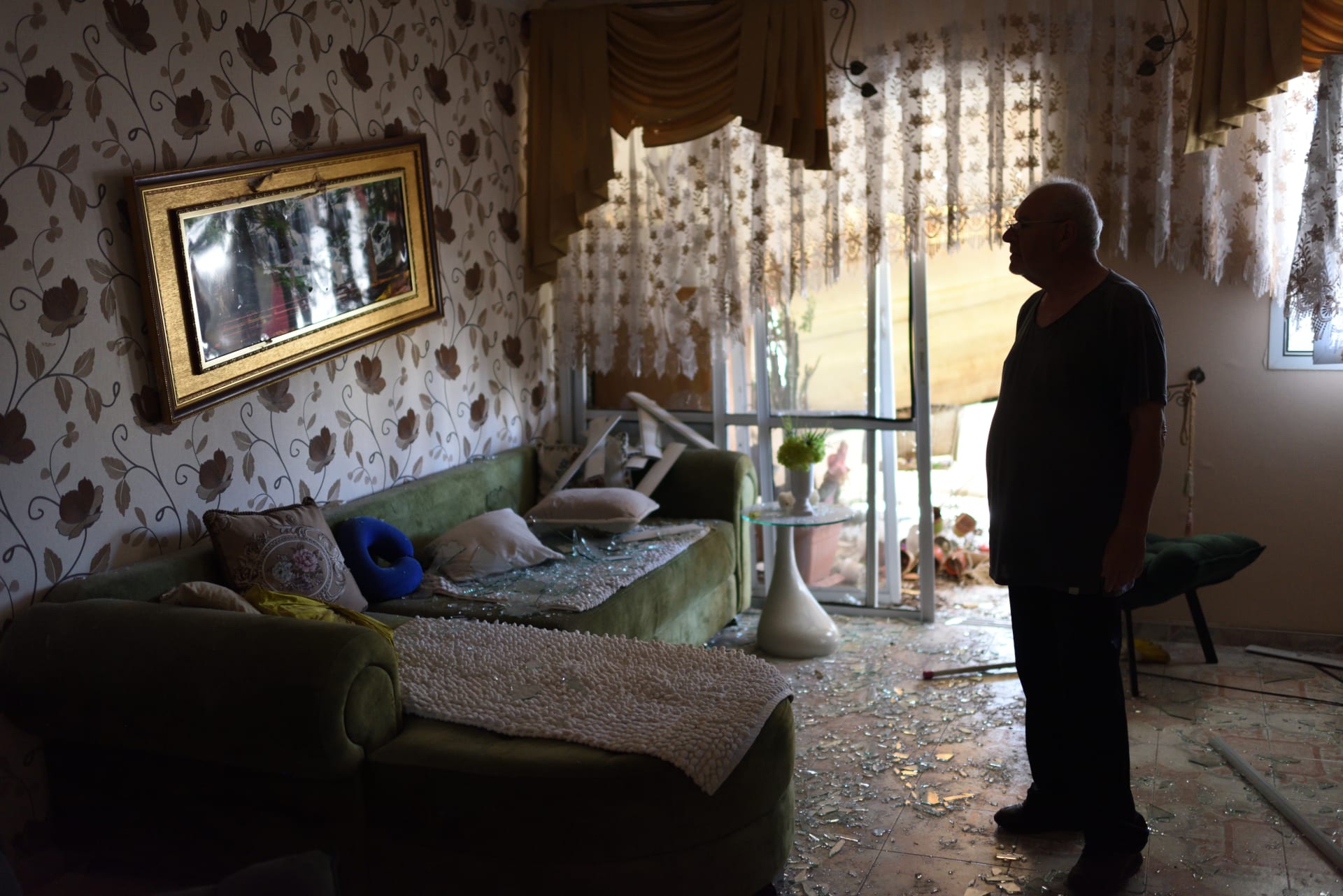 Izraelec obhlíží svůj byt poté, co budovu zasáhl šrapnel z rakety.