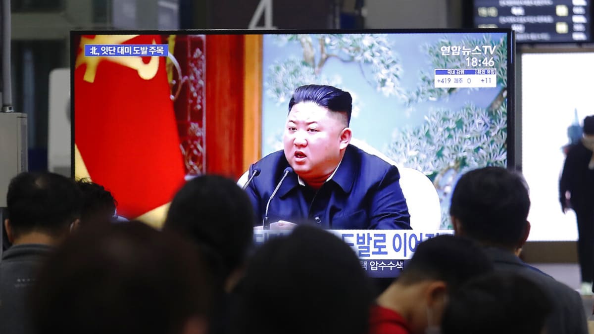 Kim Čong-un hovoří k lidem z obrazovky v televizních zprávách.