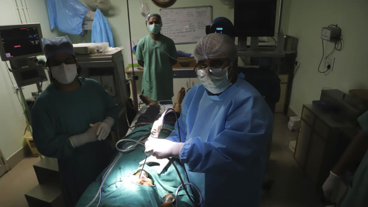 Indický lékař provádí endoskopickou operaci plísňové infekce.