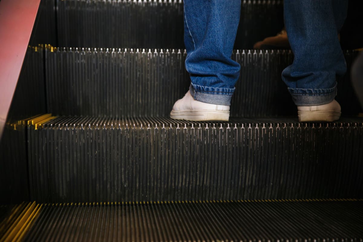 Mužské nohy na eskalátoru