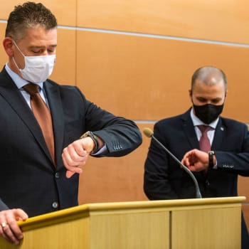 Slovenský ministr vnitra Roman Mikulec se dívá na hodinky během tiskové konference.