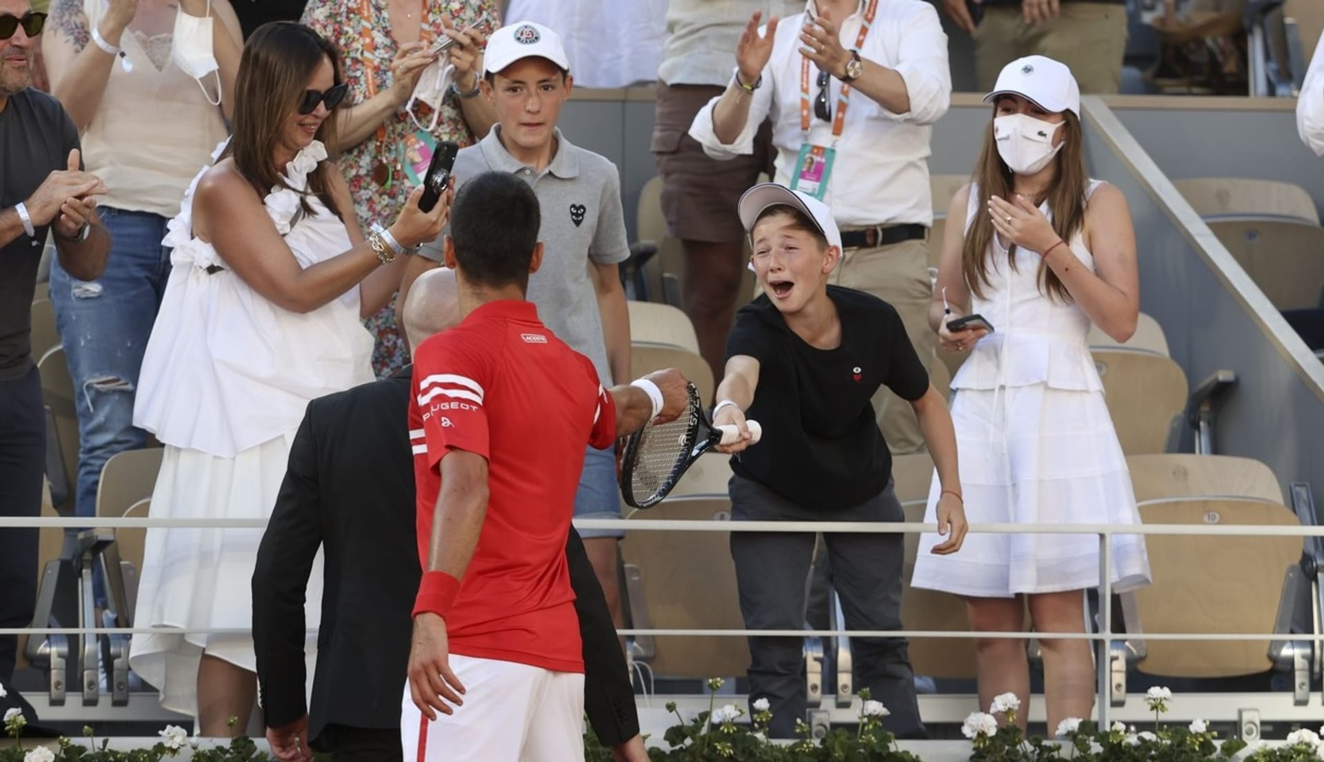 Velká radost malého fanouška, který přijímá raketu od čerstvého šampiona Roland Garros Novaka Djokoviče.