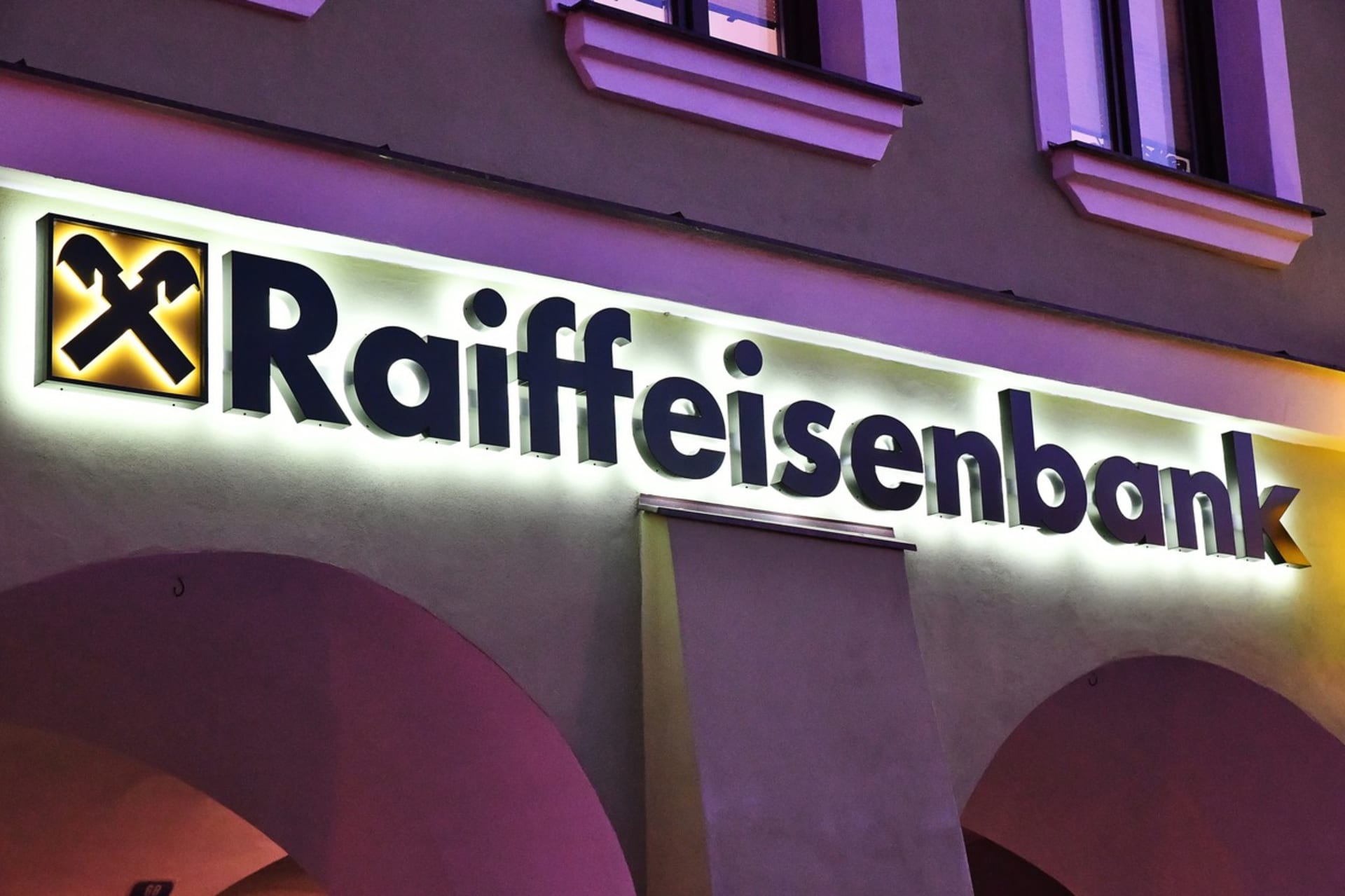 Podsvícené logo Raiffeisenbank na budově