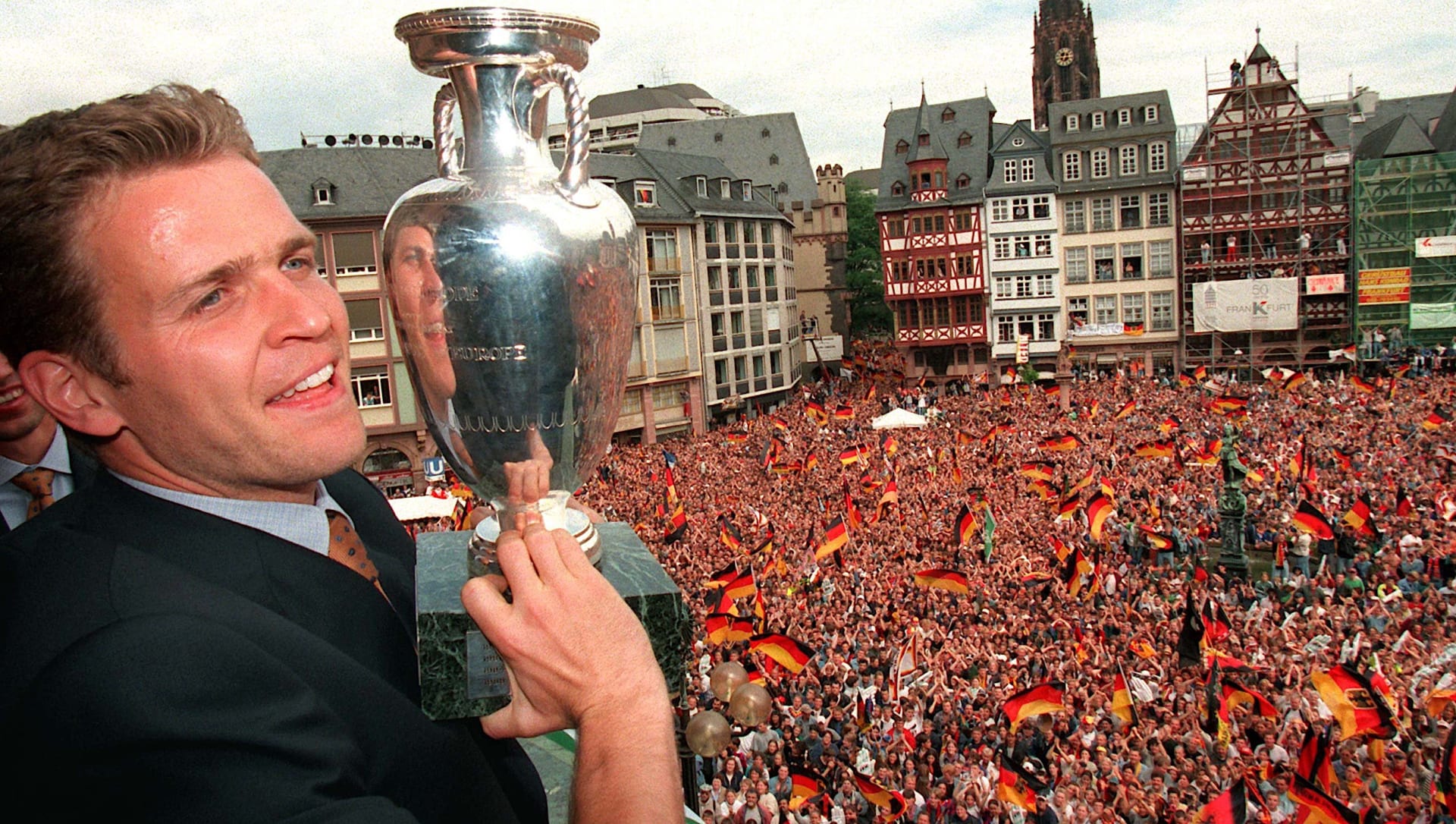 Oliver Bierhoff ukazuje fanouškům pohár mistrů Evropy 1996 z balkónu radnice ve Frankfurtu nad Mohanem. 
