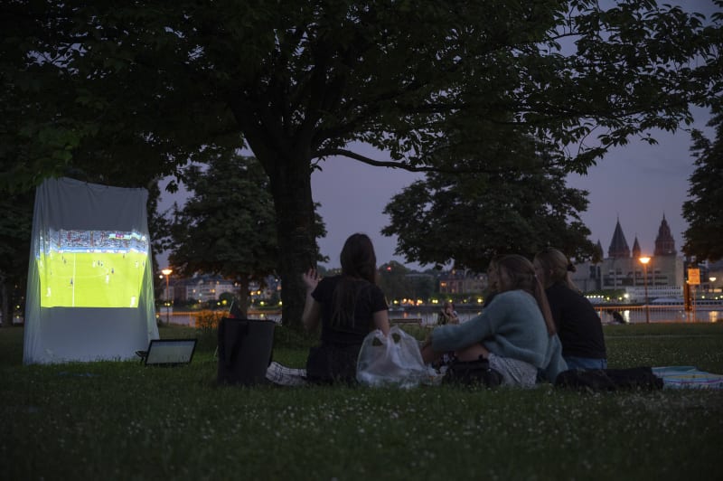 I takto se dá sledovat fotbalové Euro v době koronaviru. Velké veřejné projekce jsou zakázané, a tak ženy v německém městě Wiesbaden „pustily“ fotbal na prostěradlo v parku.