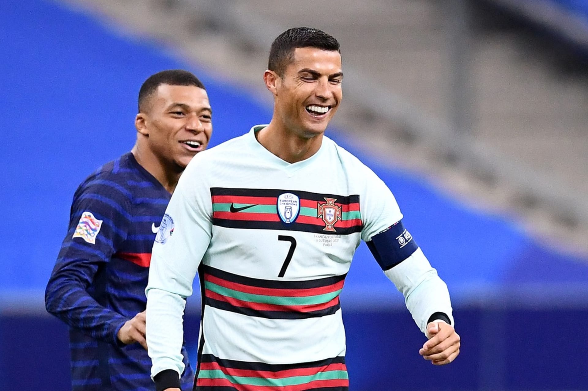 Fotbal může být zábava. Potvrzují to Kylian Mbappé a Cristiano Ronaldo (zleva) při reprezentačním zápase Ligy národů Francie–Portugalsko 11. října 2020 v Paříži. 