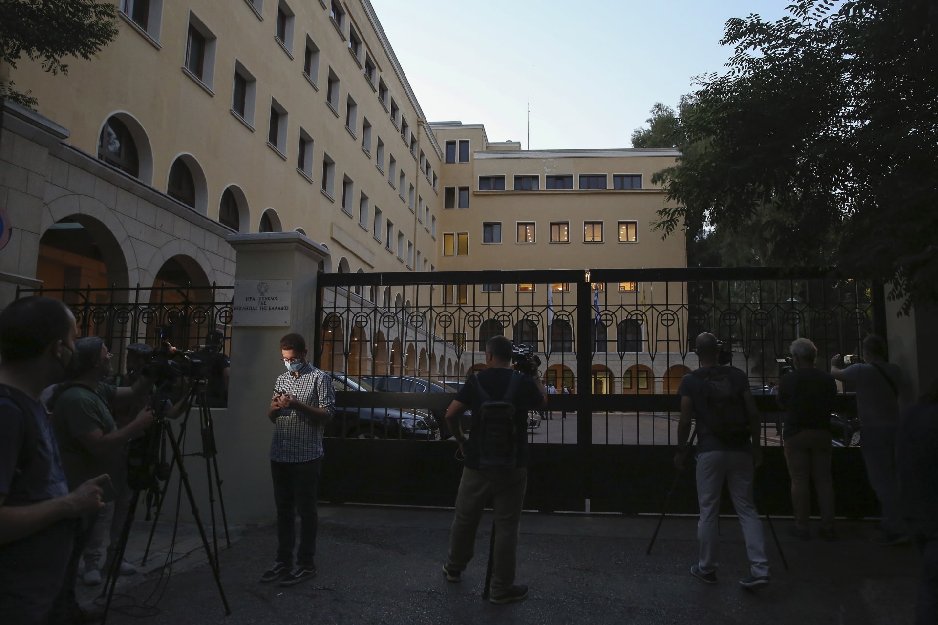 Novináři stojí po útoku kyselinou před klášterem Petraki, který je hlavním sídlem svaté synody řecké církve.