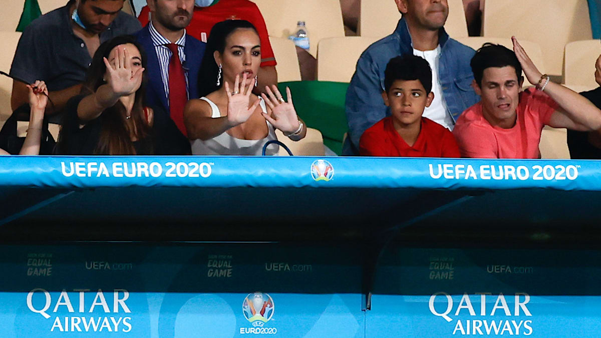 Georgina Rodriguezová se schovává před reportéry, vpravo sedí Ronaldo mladší.