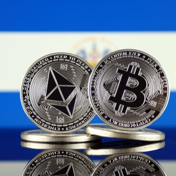 Mince bitcoinu a etherea, na pozadí vlajka Salvadoru