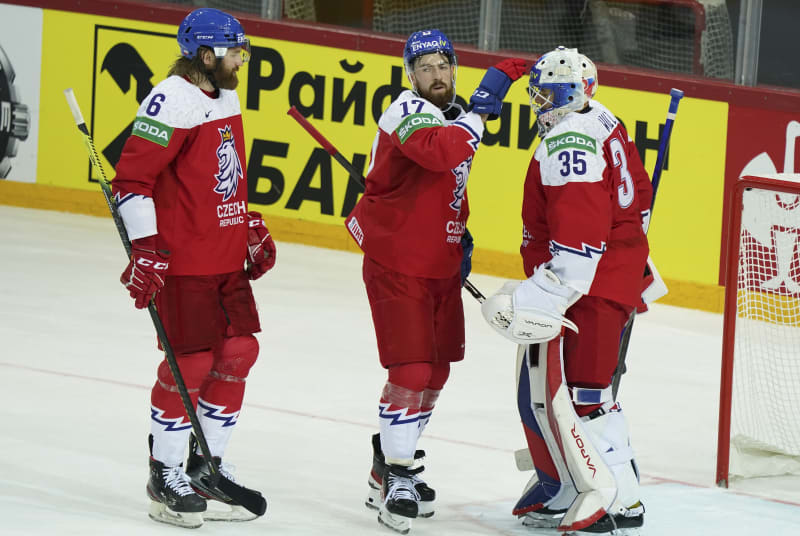 Český obránce Filip Hronek (uprostřed) blahopřeje brankáři Romanu Willovi k výkonu a vítězství nad Velkou Británií na mistrovství světa 2021 v Lotyšsku.