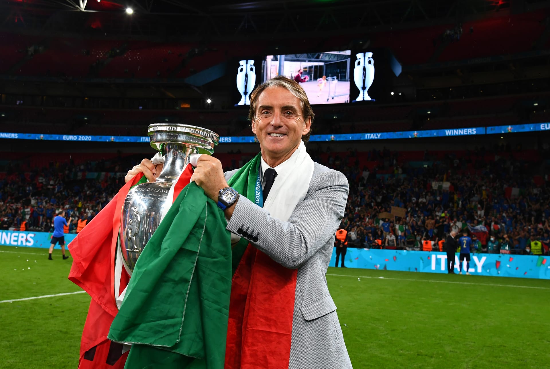 Trenér italské reprezentace Roberto Mancini s pohárem pro mistry Evropy a státní vlajkou